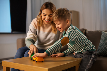 Image showing mother and son playing with toy cars at home