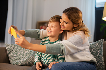 Image showing mother and son taking selfie by smartphone at home