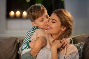 Image showing happy mother and son hugging and kissing at home