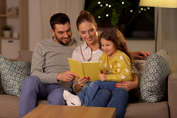 Image showing happy family reading book at home at night