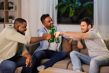 Image showing happy male friends drinking beer at home at night