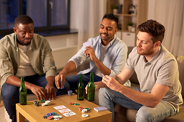 Image showing smiling male friends playing cards at home