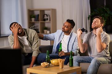 Image showing happy friends playing video games at home at night