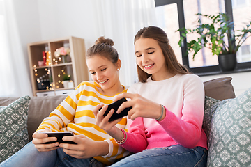 Image showing happy teenage girls with smartphones at home