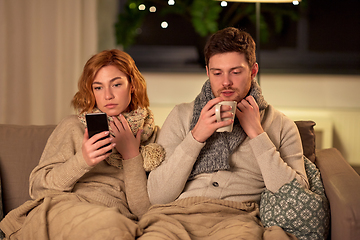 Image showing sick young couple with smartphone at home