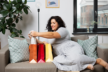 Image showing happy young woman with shopping bags at home