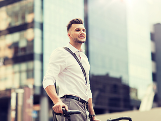 Image showing young man with bicycle on city street