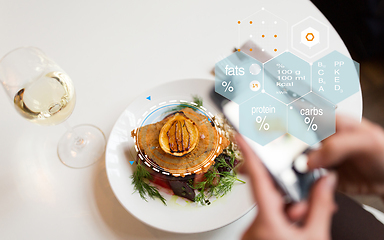 Image showing hands with phone and food nutritional value chart