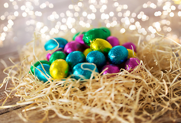 Image showing chocolate eggs in foil wrappers in straw nest