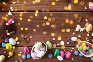 Image showing chocolate eggs and candy drops on wooden table