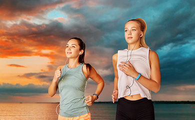 Image showing women or female friends with earphones running