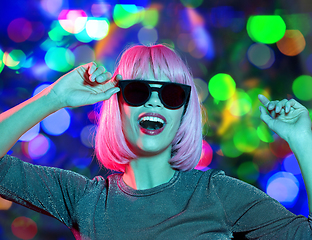 Image showing happy woman in pink wig and sunglasses dancing