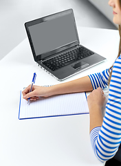 Image showing student girl with exercise book, pen and laptop