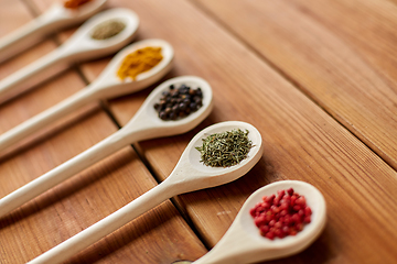 Image showing spoons with different spices on wooden table