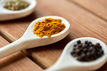 Image showing spoons with different spices on wooden table