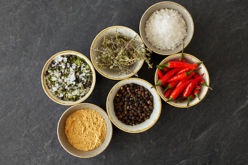 Image showing bowls with different spices on slate stone table