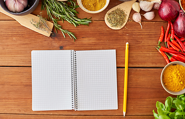 Image showing notebook with pencil among spices on wooden table