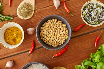 Image showing pine nuts in bowl and spices on kitchen table