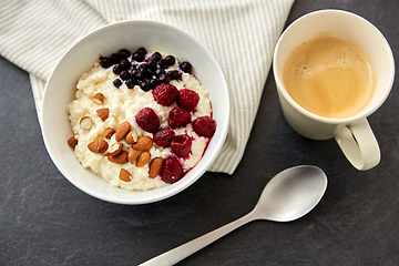 Image showing porridge breakfast with berries, almonds and spoon