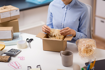 Image showing woman sticking fragile marks at post office