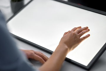 Image showing hand on led light tablet at night office