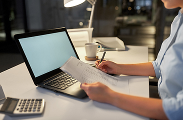 Image showing businesswoman with papers working at night office