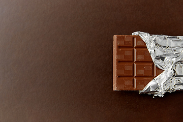 Image showing chocolate bar in foil wrapper on brown background