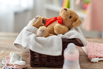 Image showing teddy bear toy in basket with baby things on table