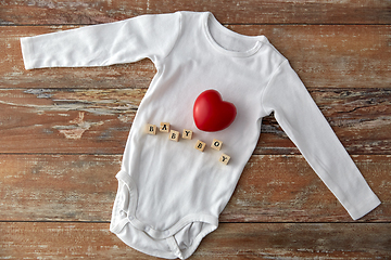 Image showing baby boy's bodysuit with red heart on wooden table