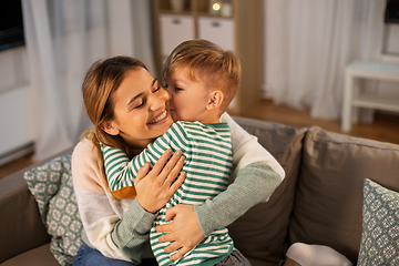 Image showing happy mother and son hugging and kissing at home