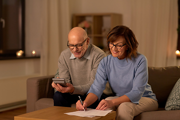 Image showing senior couple with papers and calculator at home