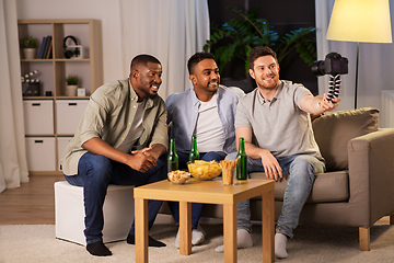 Image showing male video blogger with friends and camera at home