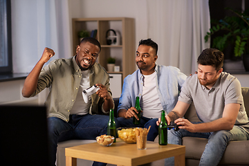 Image showing happy friends playing video games at home at night