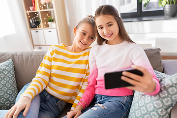 Image showing happy girls taking selfie with smartphone at home