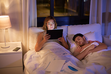 Image showing woman with tablet computer working in bed at night