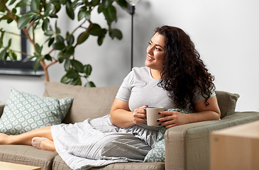 Image showing happy woman drinking coffee or tea on sofa at home