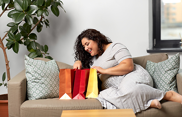 Image showing happy young woman with shopping bags at home