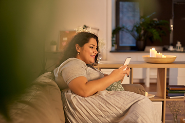 Image showing woman with smartphone at home in evening
