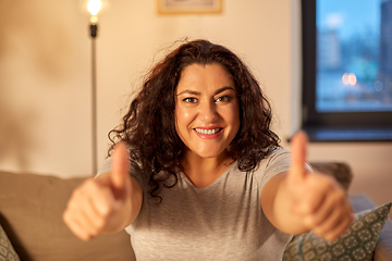 Image showing happy smiling woman showing thumbs up at home