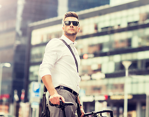 Image showing young man with bicycle on city street