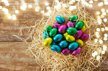 Image showing chocolate eggs in foil wrappers in straw nest