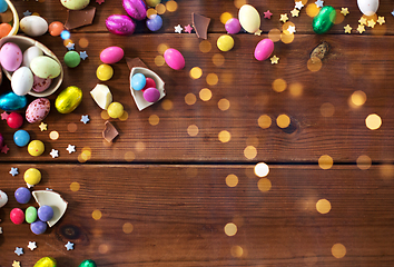 Image showing chocolate eggs and candy drops on wooden table