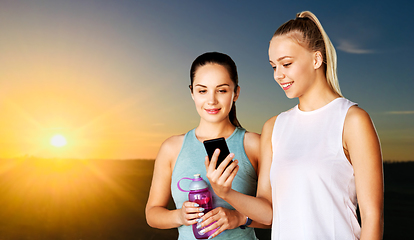 Image showing women or female friends with smartphone and flask