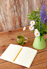 Image showing herbal tea, notebook and flowers in jug on table