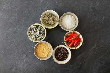 Image showing bowls with different spices on slate stone table