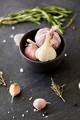 Image showing garlic in bowl and rosemary on stone surface