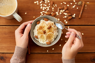 Image showing hands with oatmeal breakfast and cup of coffee