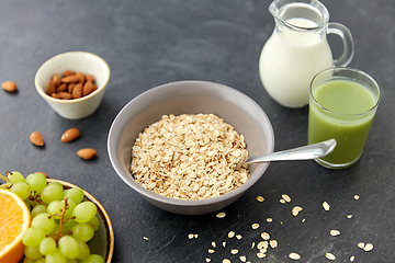 Image showing oatmeal with fruits, almond nuts and jug of milk