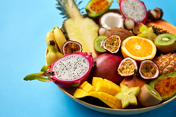 Image showing plate of exotic fruits on blue background