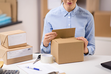 Image showing woman packing parcel box at post office